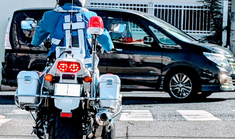 白バイが車を取り締まっている写真